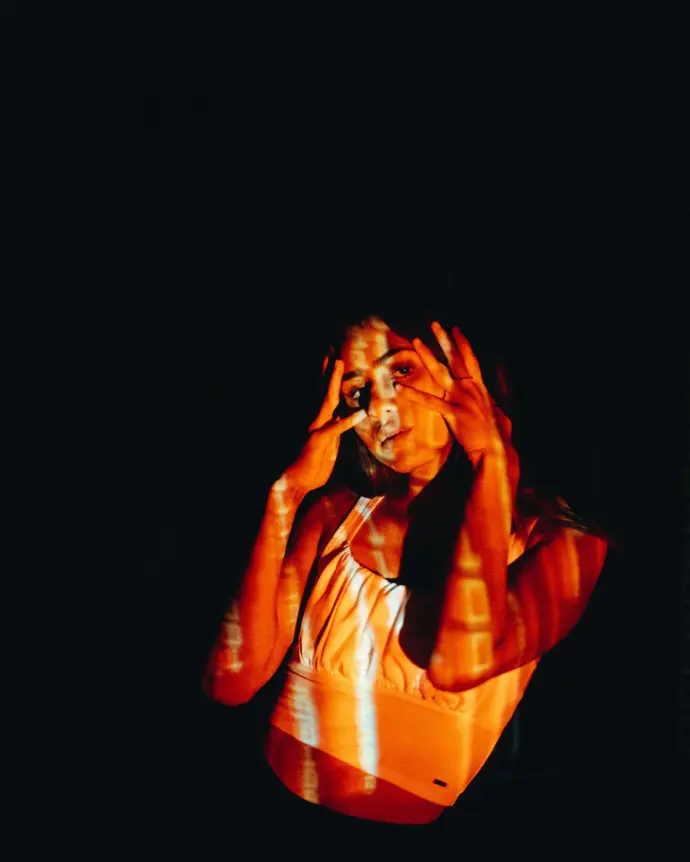 a woman with her hands on her head in the dark